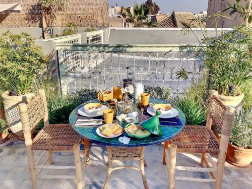 - une table avec des assiettes de nourriture sur une terrasse dans l'établissement Riad Dar Chacha, à Marrakech