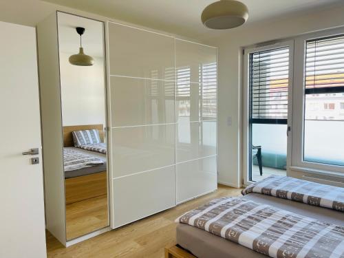 um quarto com uma divisória de vidro com uma cama e uma janela em Nová Nuselská em Praga