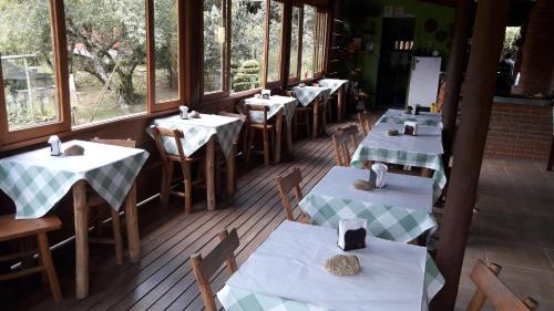 una fila de mesas y sillas en un restaurante en Pousada Chácara Pacheco, en Visconde De Maua