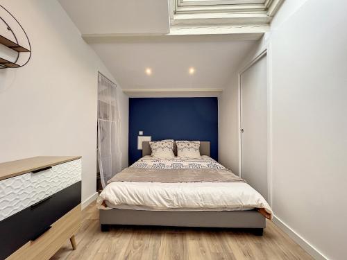 a bedroom with a bed and a blue accent wall at LE COSY - En Hyper-Centre - Rénové in Salon-de-Provence