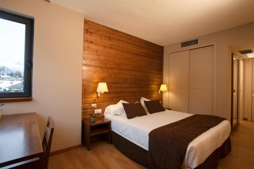 a bedroom with a bed and a table and a window at Tuc Blanc in Baqueira-Beret