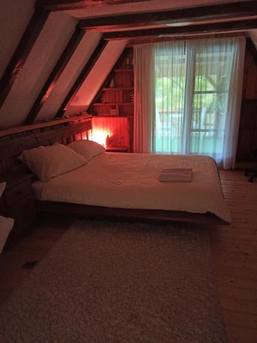 a bedroom with a large bed with a window at BUNGALOV COZY UNA in Kulen Vakuf