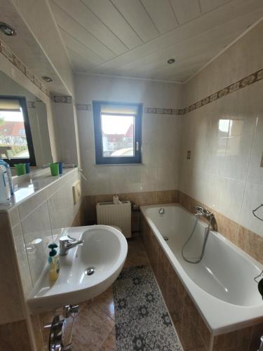 uma casa de banho com uma banheira e um lavatório e uma banheira em Ferienwohnung Familie Klingohr em Erfurt