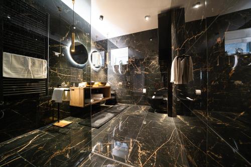 a bathroom with black marble walls and a sink at D-Palace-Lux in Donji Zemunik