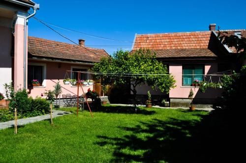 una casa con un patio con césped verde en Lugas Szallas, en Jászberény