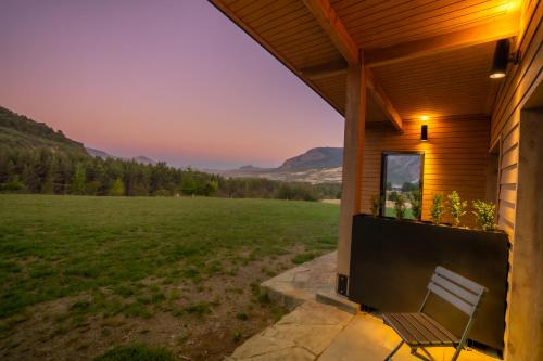 a porch of a house with a bench and a field at Calafate Apart Hotel in Coihaique