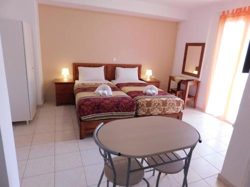 a hotel room with a bed and a table at Elatos Apartments in Klitoria