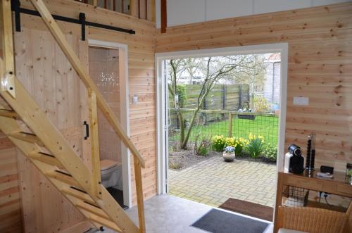 a wooden cabin with a staircase leading to a door at 'It Mearke in Molkwerum
