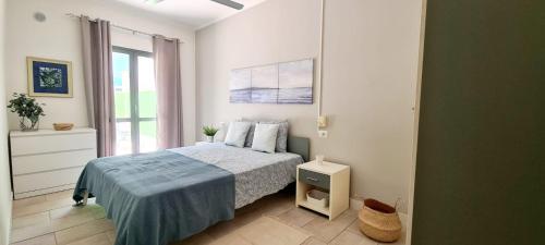 a white bedroom with a bed and a window at Pool & Wifi - Djadsal Moradias by Bobbywashere in Santa Maria