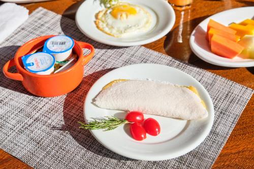 a plate of food with a sandwich and eggs and fruit at Boutique Hotel Carpe Diem in Paraty