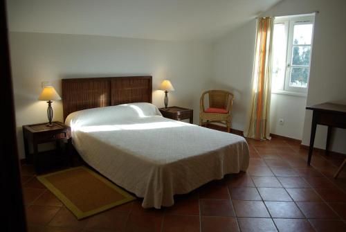 a bedroom with a bed and two chairs and a window at Domaine de Valle in Sorbo-Ocagnano