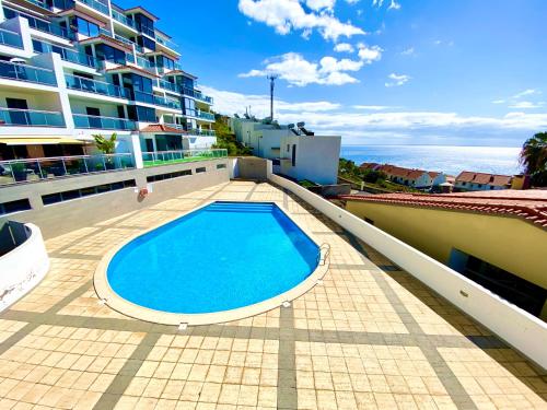 a swimming pool on the roof of a building at Rubeus in Caniço