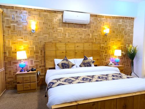 ein Schlafzimmer mit einem großen Bett und zwei Lampen in der Unterkunft Indus Lodges Gilgit in Gilgit