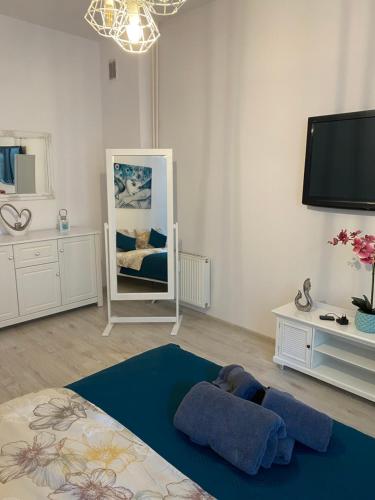 a living room with a mirror and a tv at Apartament White in Olsztyn