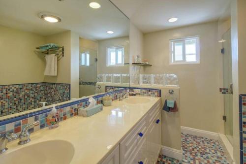 a bathroom with two sinks and a large mirror at The Bridge At South Oceanside is the Perfect Family Beach House now with AC in Oceanside