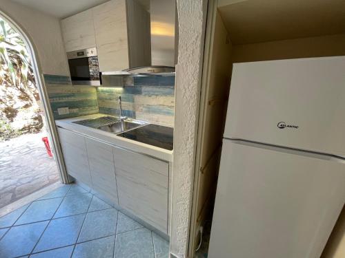 una cucina con frigorifero bianco e lavandino di Mono 4 posti vista mare "Il Portolano" a Porto Azzurro