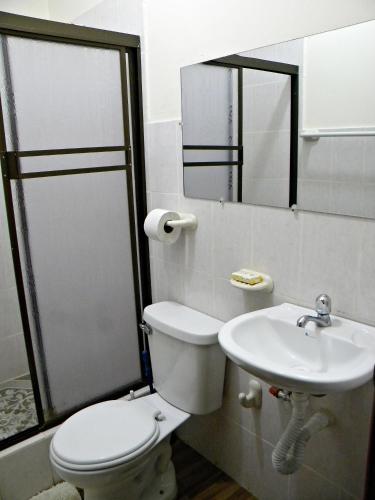 a bathroom with a toilet and a sink at Casa Blanca Puerto López in Puerto López