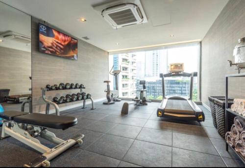 a fitness room with a gym with a large window at Tastoria Collection Sukhumvit in Bangkok