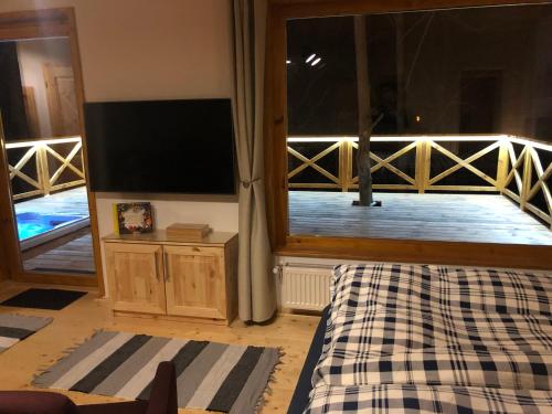 sala de estar con TV y balcón en Őzlak Lombház, en Zalaújlak