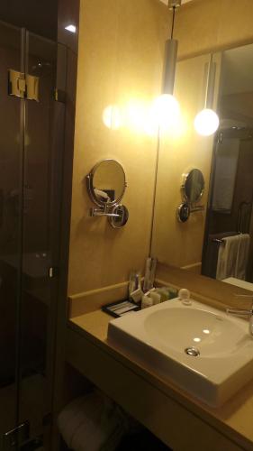a bathroom with a sink and a mirror at Amman Airport Hotel in Al Qasţal