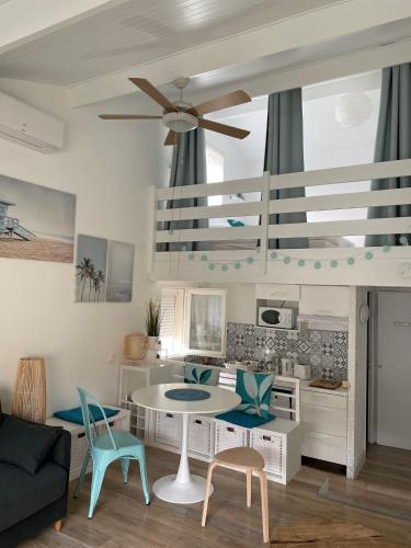 un salon avec une table et des chaises dans l'établissement Maison à 300m de la plage, quartier calme, à Mimizan