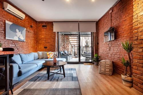 a living room with a blue couch and a brick wall at Origine Rentals Galata Tower in Istanbul