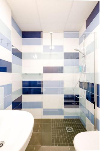 a bathroom with a blue and white striped wall at Hotel am Zoo in Neunkirchen