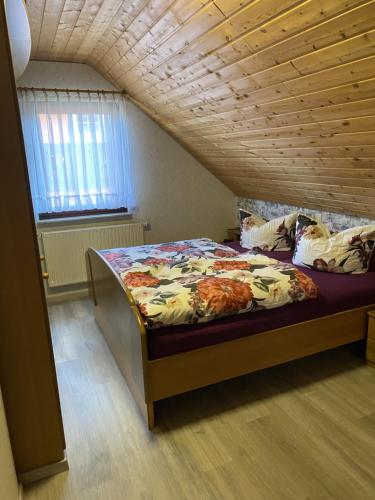 a bed in a room with a wooden ceiling at Ferienwohnung Familie Putschke in Nohra