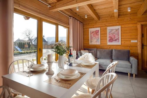 een eetkamer met een tafel en stoelen en een bank bij Bajkowe Domki in Kudowa-Zdrój