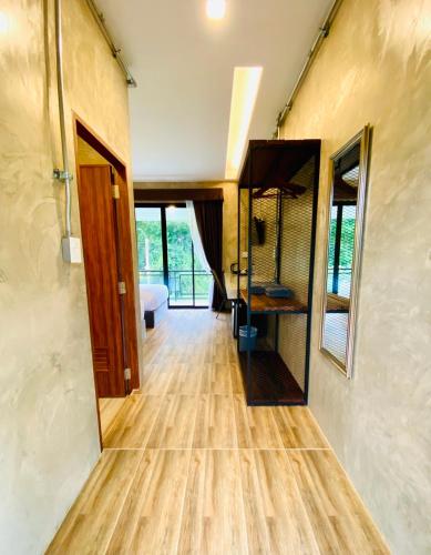 a hallway of a home with wooden floors and a bathroom at บ้านต้นไม้โฮมสเตย์อุทัยธานี in Uthai Thani
