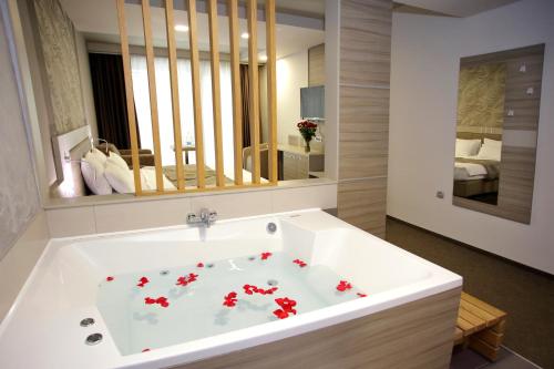 a bath tub with red flowers on it in a bathroom at Terme Paradiso - Hotel Paradiso in Dobova