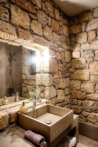 a stone walled bathroom with a large bath tub at Euphoria Suites in Avia