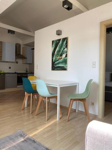 a dining room with a white table and chairs at Das Bergl in Rosegg