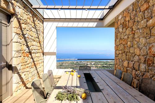 a dining room with a table and a stone wall at Euphoria Suites in Avia