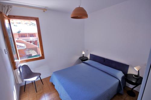 a bedroom with a blue bed and a window at Sa di Mare in Bibione
