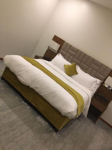 منتجع وشاليهات وسام بارك Wesam Park Residences & Chalets في الطائف: غرفة نوم بسرير كبير مع ملاءات ووسائد بيضاء