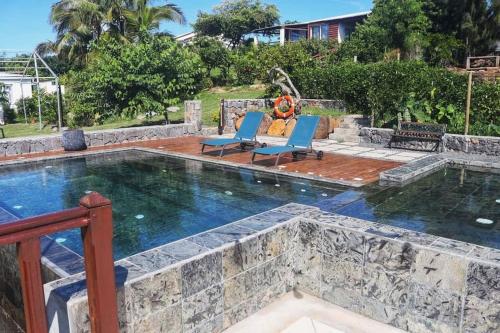 Rodrigues Island的住宿－弗歐薩法特山林小屋，一个带2把躺椅的游泳池和一个游泳池