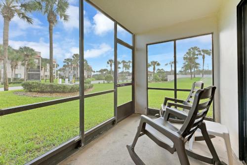 two chairs sitting on a porch looking out at the grass at Ocean Village Club N14 in Saint Augustine