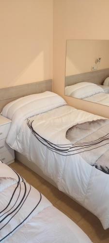 three beds in a room with a mirror at San Marcos in Seseña Nuevo