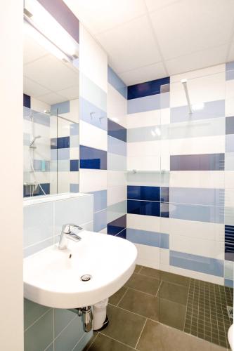 a bathroom with a white sink and blue and white stripes at Hotel am Zoo in Neunkirchen
