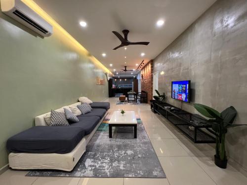 a living room with a couch and a tv at R3troHouse 3BR 8PAX PS4,POOL TABLE,NETFLIX in Kuantan