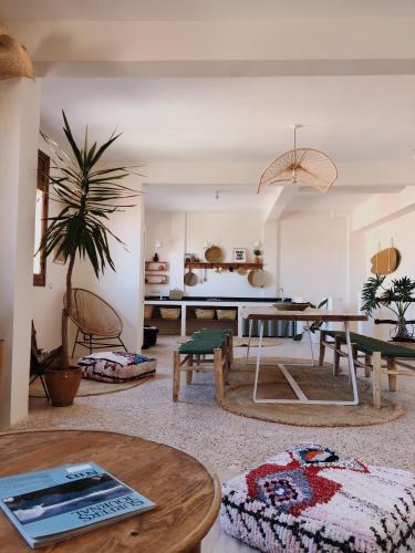 a living room with a table and a dining room at SwellHouse in Tamraght Ouzdar