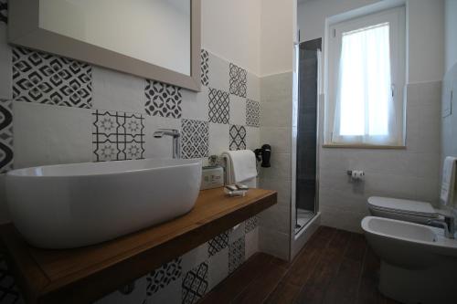 bagno con grande lavandino bianco e servizi igienici di Stella Marina Paestum a Capaccio-Paestum