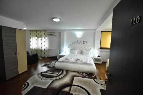 a bedroom with a large white bed in a room at Hotel Euphoria in Craiova