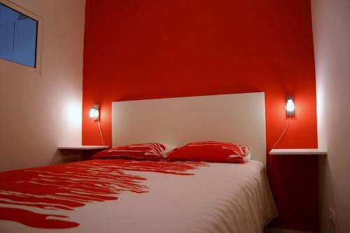 1 dormitorio con paredes rojas y 1 cama con almohadas rojas en Lisbon Apartment, en Lisboa