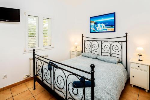 a bedroom with a black bed and a tv at Apartment Cadaques in Cadaqués