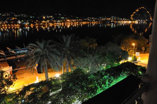 a view of the water at night with palm trees at Hotel Bokeljski Dvori in Kotor