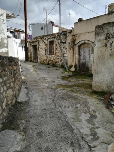 an empty street in an old building with a door at Gallery House Plouti in Ploutí