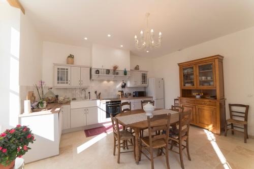 une cuisine avec une table et une salle à manger dans l'établissement Château Biset, à Saint-Philippe-du-Seignal