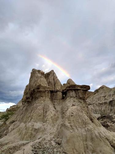 a rainbow over a rock formation with a mountain at Hostal Arámbulo in Villavieja